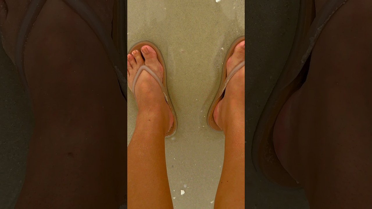 Chancletas Crocs Miami color beige usadas sobre la arena mojada