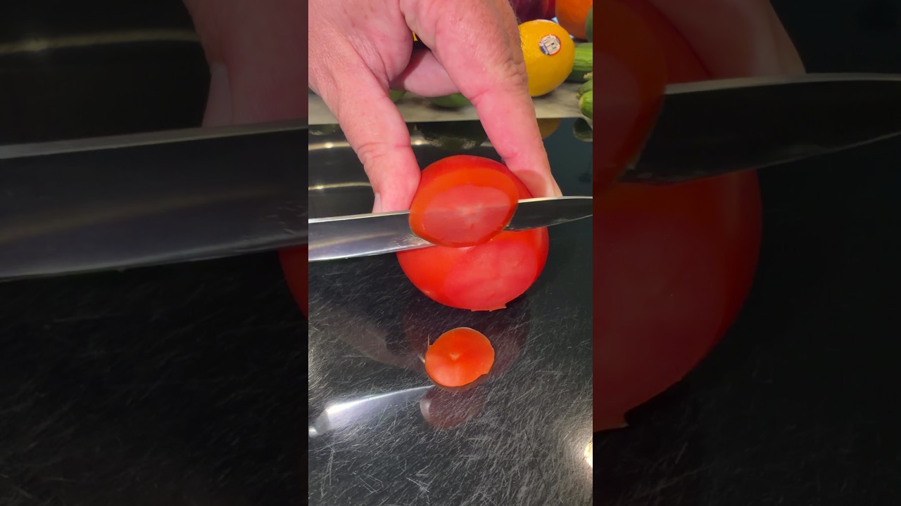 Cuchillo Ninja NeverDull cortando una rodaja fina de tomate