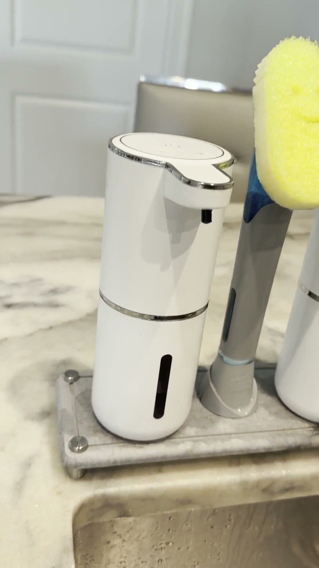 Dispensador automático de jabón blanco junto al fregadero