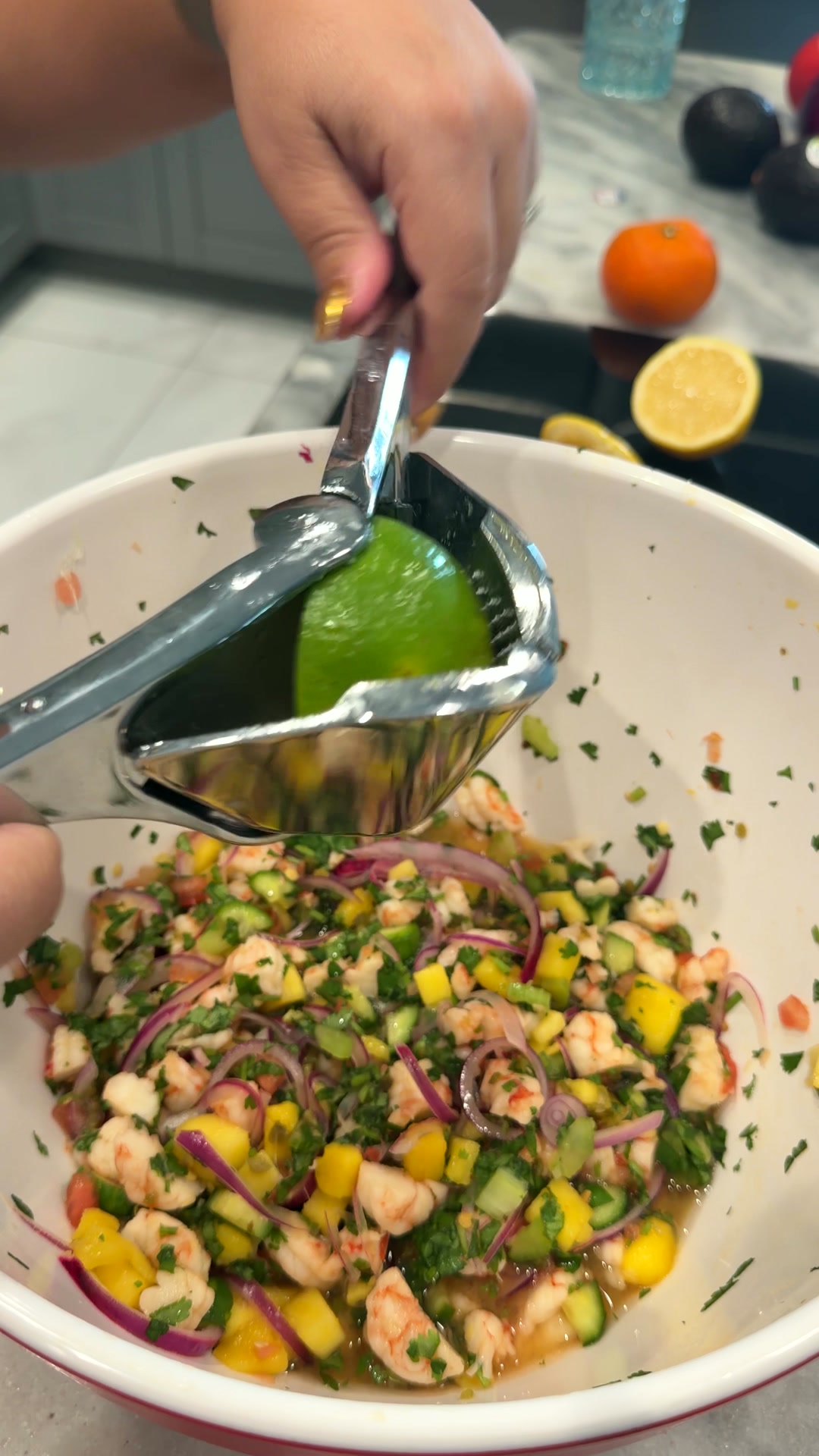 Exprimidor de acero prensando una lima sobre un bol de ceviche