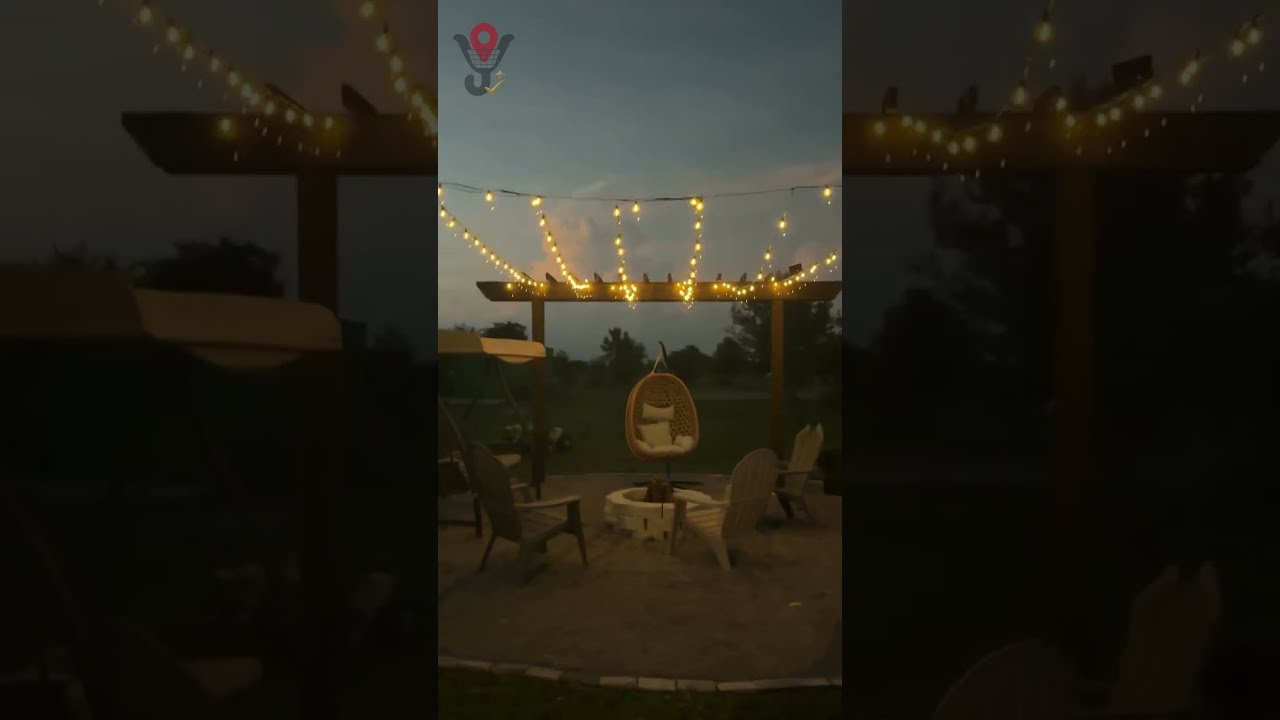 Guirnalda de luces solares encendida sobre un patio con fire pit
