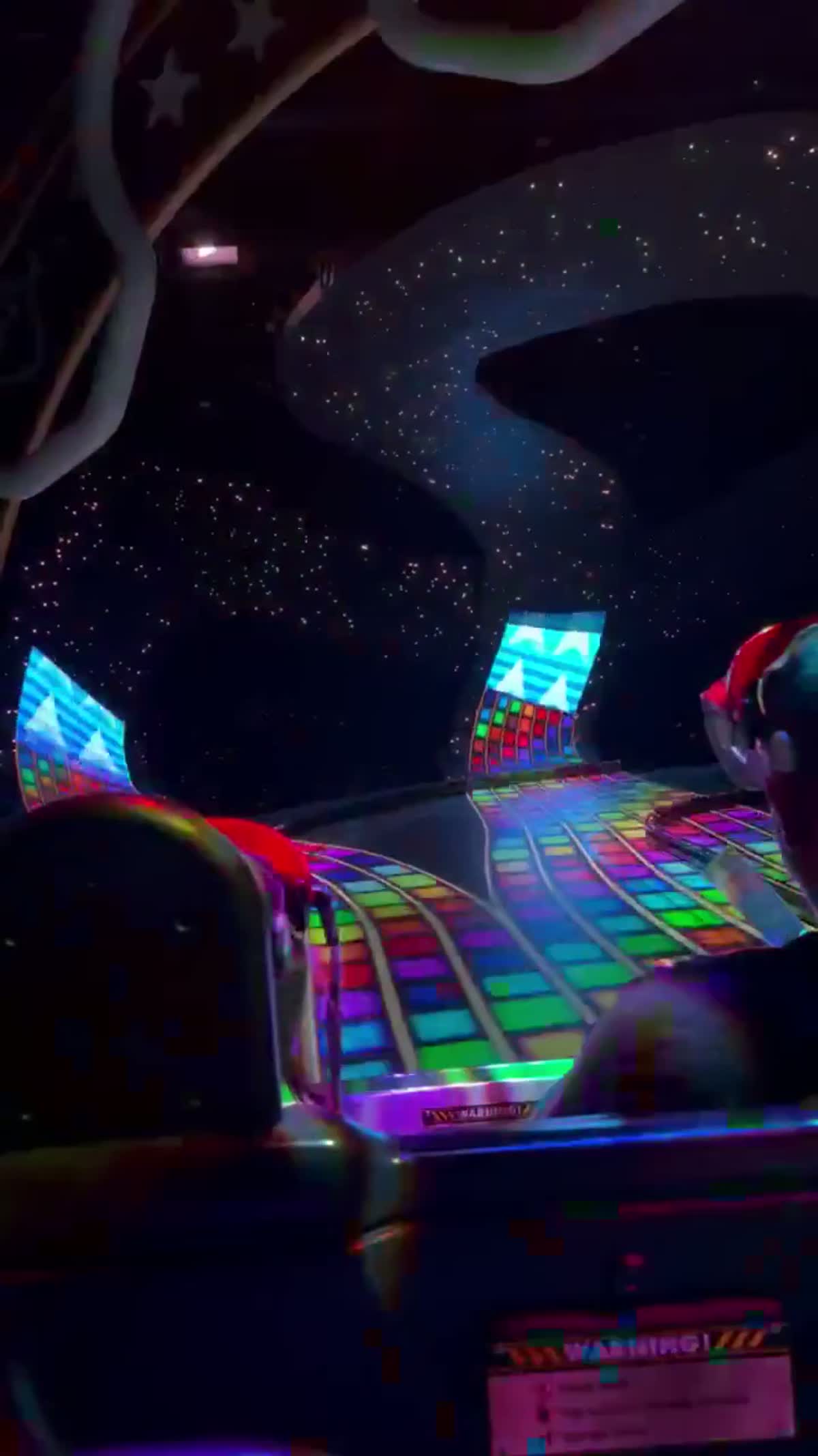 Escena iluminada de Rainbow Road dentro de la experiencia Mario Kart