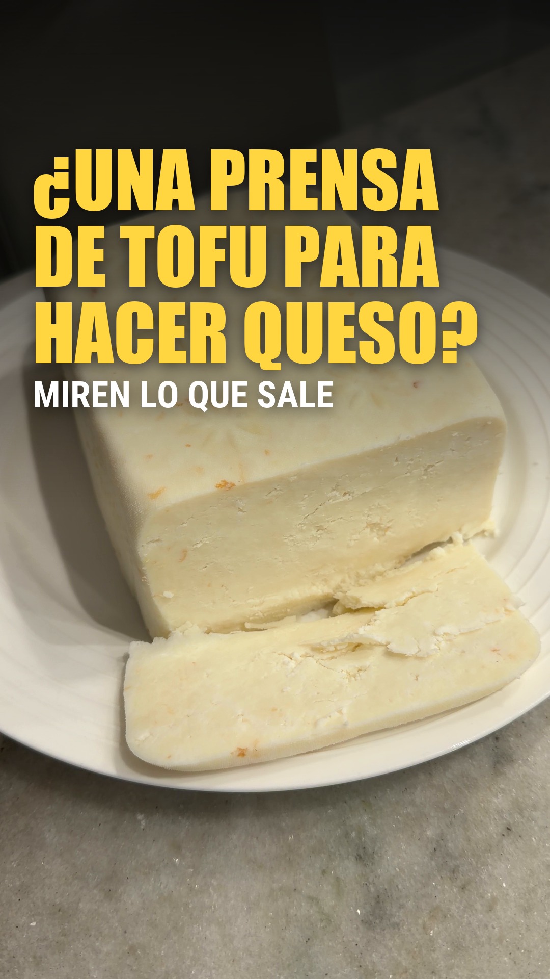 Queso casero cortado sobre un plato, hecho con una prensa de tofu