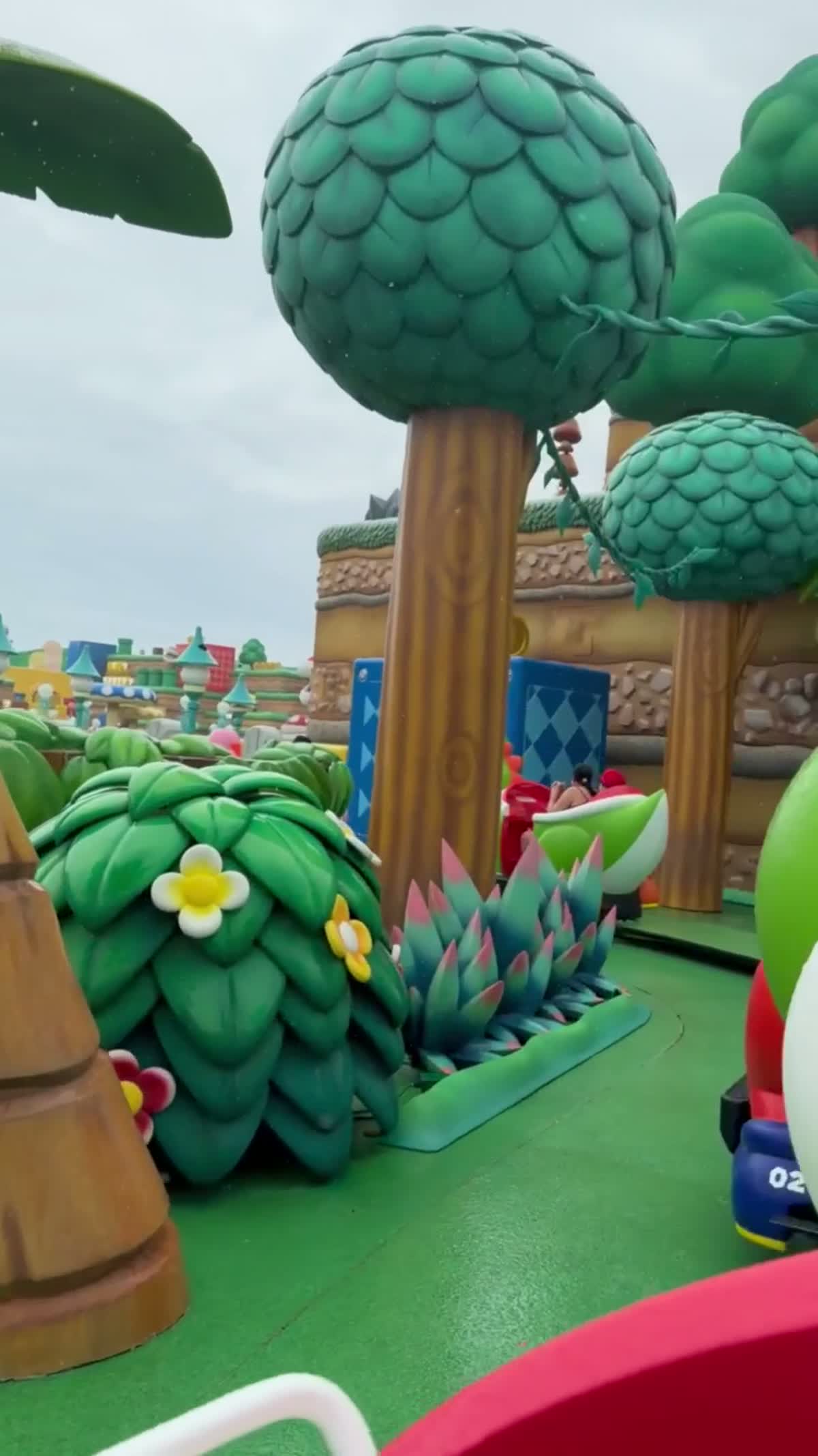 Escenario verde y colorido de Super Nintendo World visto desde la atracción de Yoshi