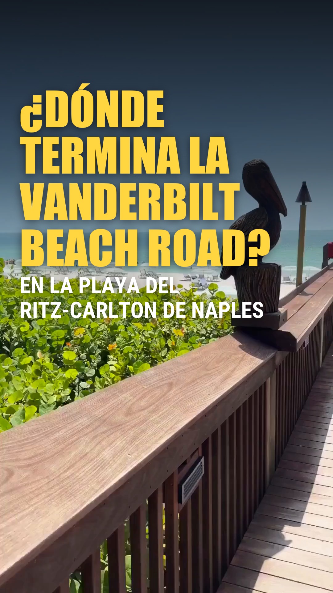 Pasarela de madera con una figura de pelícano y vista a la playa junto al Ritz-Carlton de Naples