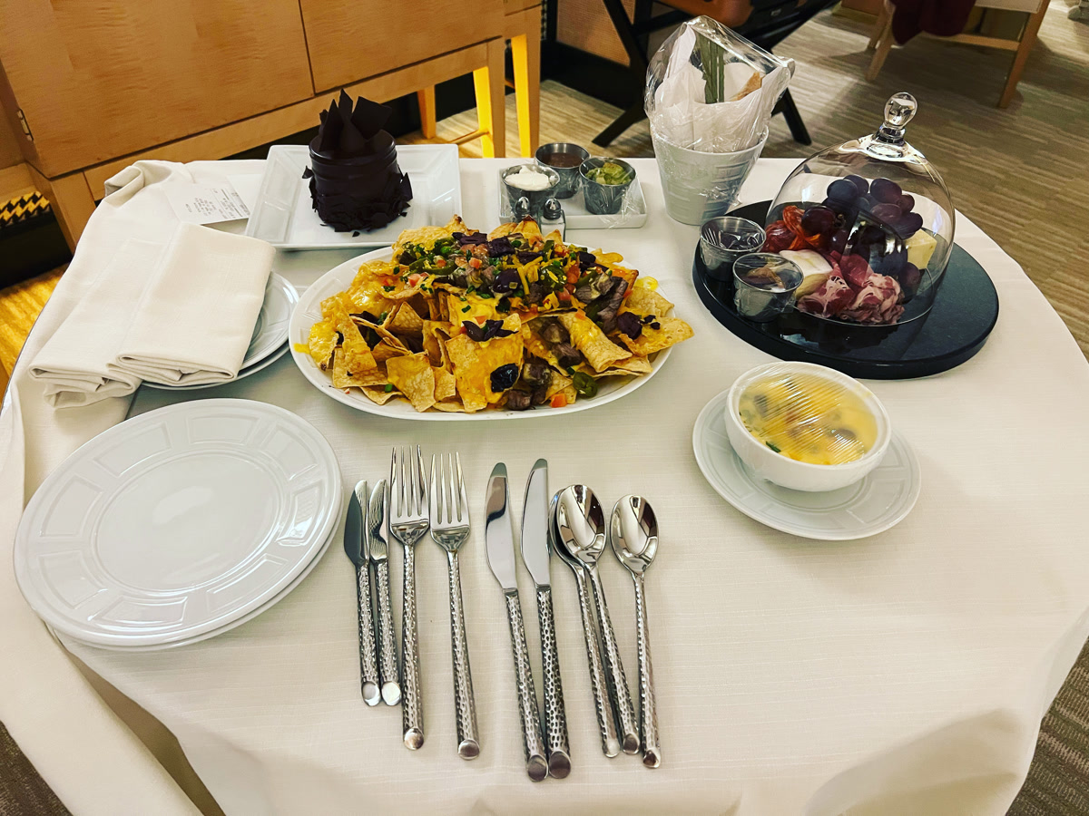 Mesa del room service con nachos, fruta y pastel de chocolate durante la estancia de Yane